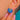Scallop shell earring, angled worn detail of the turquoise and deep blue Enamel